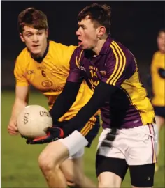  ??  ?? Tom Byrne of Wexford sizes up his options as D.C.U. defender Kevin Feely closes in.