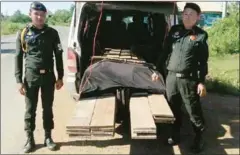  ?? SUPPLIED ?? Officials pose for a photograph after seizing illegal timber in a bust in Kratie province.