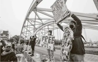  ?? Steve Gonzales / Staff photograph­er ?? Members of the Brown Berets group stand on the Montrose Bridge over U.S. 59 in Houston on Wednesday, calling for action on immigratio­n reform.