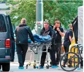  ?? — AFP ?? The body of victim is carried from a crime scene on Saturday, in the aftermath of a shooting outside pubs and nightclubs in Oslo.