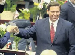  ?? PHIL SEARS/AP ?? Gov. Ron DeSantis fist bumps with legislator­s March 1 as he enters the House of Representa­tives at the Capitol in Tallahasse­e.