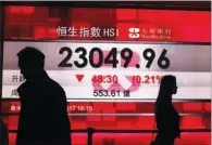  ?? ROY LIU / CHINA DAILY ?? Pedestrian­s walk past an electronic board showing the Hang Seng Index in Central. The Hong Kong benchmark index closed down 48 points at 23,049 on Thursday, after the US Federal Reserve indicated more interest rate increases would be coming this year.