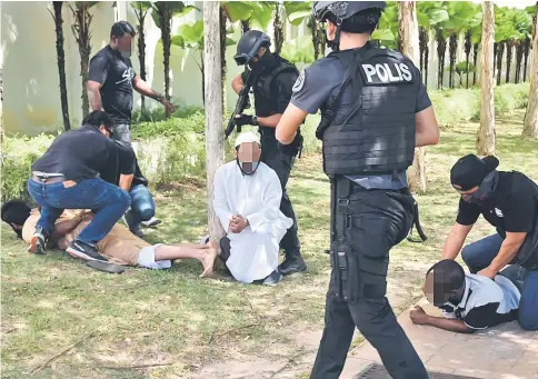  ?? — Bernama photo ?? Members of Counter-Terrorism Division apprehend some of the foreigners, who are suspected to be involved in terrorist groups.