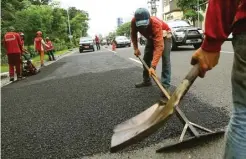  ?? DIPTA WAHYU/JAWA POS ?? PANEN KELUHAN: Petugas DPUBMP memperbaik­i ruas jalan yang rusak di Jalan Ahmad Yani.