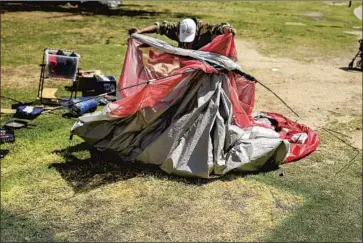  ?? Wally Skalij Los Angeles Times ?? A HOMELESS man takes down his tent before leaving Echo Park. Some of the people living in the park were taken to hotels, while others stayed put. The encampment has become a f lashpoint for residents and activists.