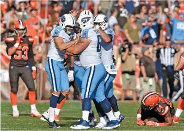  ?? THE ASSOCIATED PRESS ?? Tennessee Titans kicker Ryan Succop, left, celebrates with teammates after making a game-winning 47-yard field goal in overtime in Sunday’s game in Cleveland. The Titans won 12-9.