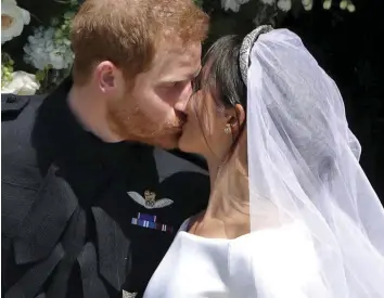  ??  ?? Wedding day: Meghan’s friend Jessica Mulroney (in blue) and Kate with flower girls. Left, Harry and Meghan kiss