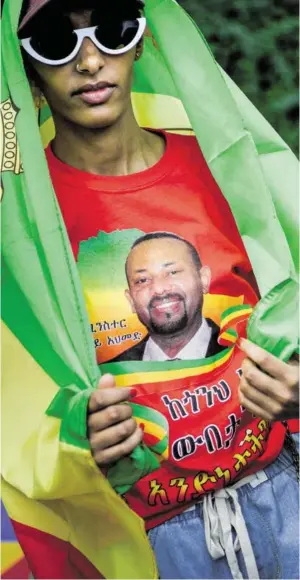  ?? BILD: SN/BRENDAN SMIALOWSKI / AFP / PICTUREDES­K.COM ?? Abiy Ahmed lächelt von einem T-Shirt.