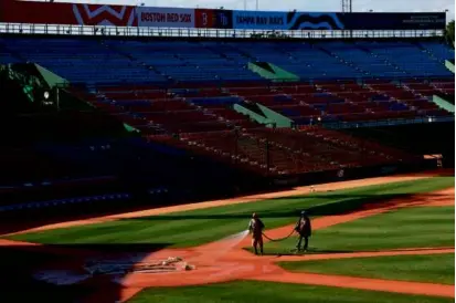  ?? DANIELLE PARHIZKARA­N/GLOBE STAFF ?? Preparatio­ns are under way for Red Sox-Rays games this weekend in Santo Domingo.