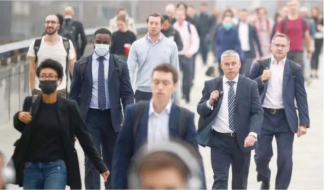  ?? Reuters ?? ↑
Commuters walk across the London Bridge during the morning rush hour in London on Monday.