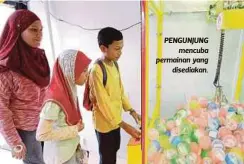  ??  ?? PENGUNJUNG
mencuba permainan yang
disediakan.