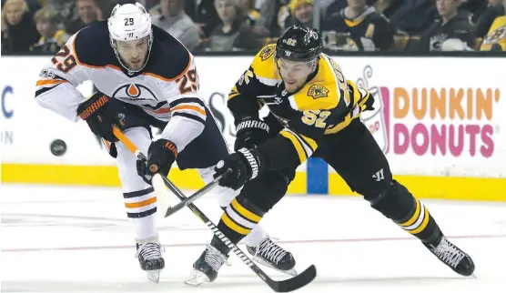  ?? PHOTOS: MARY SCHWALM/THE ASSOCIATED PRESS ?? Oilers centre Leon Draisaitl and Bruins centre Sean Kuraly vie for the puck during the second period of Sunday’s game in Boston. The Oilers played one of their best games of the season on the way to a 4-2 victory.