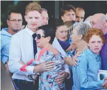  ??  ?? Mum Julie Dixson is held by her eldest son as family and friends farewell Sunshine Coast teen Jade Dixson.