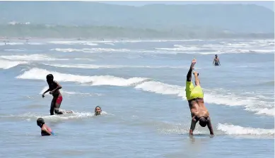  ?? LUIS RODRÍGUEZ LEZAMA Y ARCHIVO ?? Muchas familias decidieron bañarse en las playas de Puerto Colombia, a pesar del cierre de la misma.