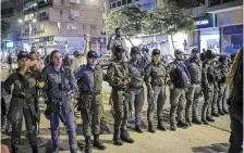  ?? ?? Police stand guard outside a Tel Aviv salon where protesters demonstrat­ing against the government’s planned judicial overhaul amassed on Wednesday after learning that the prime minister’s wife, Sara Netanyahu, was getting her hair done inside.