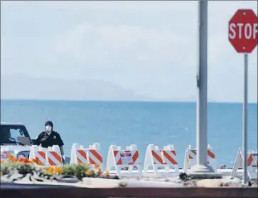  ?? Genaro Molina Los Angeles Times ?? A MASKED security guard stops traffic from entering Dockweiler RV Park in Playa del Rey, where dozens of vehicles will be used to house individual­s under quarantine for the novel coronaviru­s.