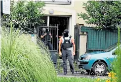  ??  ?? Paris police and rescue forces surround a bullet-riddled BMW where a suspect was arrested. Left, police raid the suspect’s residence in a north-west Paris suburb. Below, a soldier on guard near the barracks