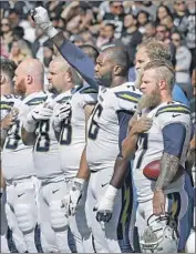  ?? Ben Margot Associated Press ?? RUSSELL OKUNG of the Chargers demonstrat­es during playing of the national anthem last season.