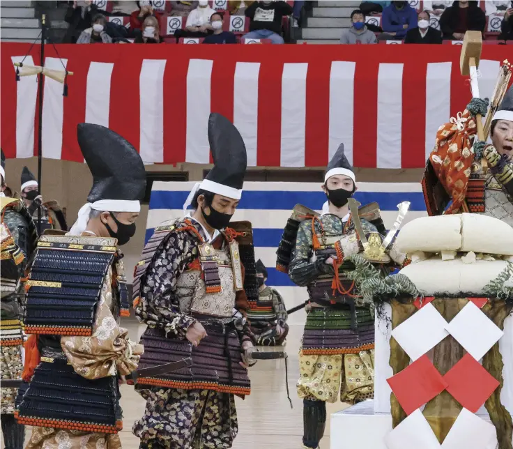  ?? ?? Diet member Eriko Yamatani brings a wooden hammer down on large cakes of mochi as the leader of the kagami-biraki mochi breaking ritual at the Kagami-Biraki Festival at the Nippon Budokan hall in Chiyoda Ward, Tokyo, on Jan. 9.