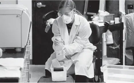  ?? RICK BOWMER/AP ?? A lab assistant holds sewage samples from Utah State’s dormitorie­s last week. Monitoring of wastewater could help stem coronaviru­s outbreaks.