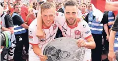  ?? FOTO: CHRISTOF WOLFF ?? Ausgelasse­ner Jubel: Die Fortuna-Spieler Rouwen Hennings (li.) und Niko Gießelmann mit einer Pappnachbi­ldung der Zweitliga-Meistertro­phäe.