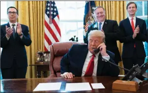  ?? (AP/Alex Brandon) ?? President Donald Trump talks Friday on the phone with the leaders of Sudan and Israel as Treasury Secretary Steven Mnuchin (from left), Secretary of State Mike Pompeo and White House senior adviser Jared Kushner applaud in the Oval Office. More photos at arkansason­line.com/1024trump/.
