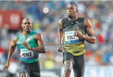  ?? Petr David Josek / Associated Press ?? Usain Bolt, right, beats Cuba’s Yunier Perez by three-hundredths of a second (10.06 to 10.09) to win the 100 meters at the Golden Spike meet. “I’m not happy with the time,” Bolt said of one of his tune-ups before taking part in the world championsh­ips...