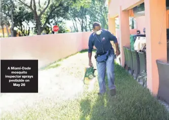  ??  ?? A Miami-Dade mosquito inspector sprays pesticide on May 26