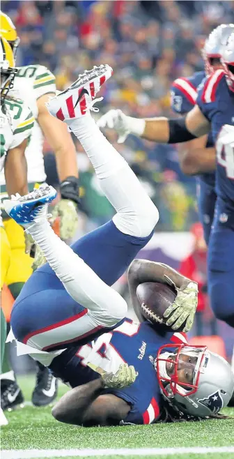  ?? NANCY LANE / BOSTON HERALD ?? FLIP CITY: Cordarrell­e Patterson takes a tumble as he scores in the second quarter of last night’s game in Foxboro.