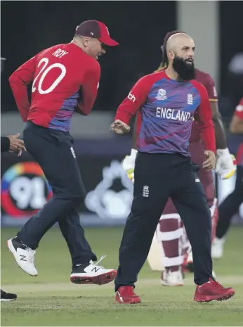  ?? AP ?? England’s Moeen Ali, right, celebrates the dismissal of West Indies’ Lendl Simmons, the first of his two wickets. He also took a fine catch to earn the man of the match award in Dubai