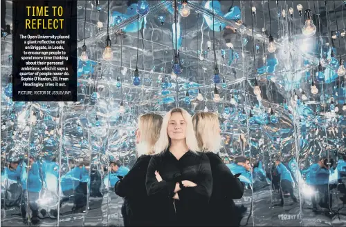  ??  ?? The Open University placed a giant reflective cube on Briggate, in Leeds, to encourage people to spend more time thinking about their personal ambitions, which it says a quarter of people never do. Sophie O’Hanlon, 20, from Headingley, tries it out.