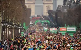  ?? — AFP ?? Runners compete during the start of the 42nd edition of the Paris Marathon on Sunday. Kenya’s Paul Lonyangata held onto his title to win this year’s marathon in the men’s group with an official time of 2 hours, 6 minutes and 25 seconds.