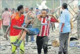  ?? REUTERS ?? ▪ A man injured in a suicide car bomb explosion in Mogadishu being taken away.