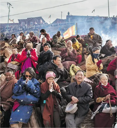  ?? KEVIN FRAYER / GETTY IMAGES FILES ?? Tibetan Buddhists pray on a hillside in the remote Garze Tibetan Autonomous Prefecture, Sichuan province, China. They are among four religious groups facing high levels of persecutio­n, according to Freedom House.