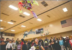  ??  ?? Fortino Contreras, 9, of Lodi, tries to get more candy out of the piñata during St. Anne’s Catholic Church’s Las Posadas celebratio­n in Lodi on Wednesday