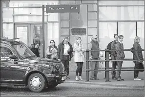  ?? Bloomberg News ?? Passengers line up for taxis outside a rail station in London in this file photo. London’s transporta­tion agency on Friday decided not to renew ride-hailing service Uber’s license to operate.