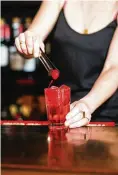  ?? LANNA APISUKH/THE NEW YORK TIMES ?? A bartender tops off a Dirty Shirley with maraschino cherries, just like the kid-friendly drink, at Fanelli’s Cafe in New York. Vodka-spiked Shirley Temples, nostalgic, colorful and unapologet­ically sweet, have found a way to upstage the vodka soda.
