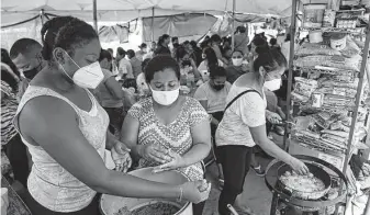  ?? Jerry Lara / Staff file photo ?? Migrant women cook food July 26 for a crowd camped out at Plaza de la Republica in Reynosa, Mexico. The U.S. is still enforcing Title 42 travel restrictio­ns.