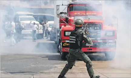  ?? ANDRÉS MARTÍNEZ CASARES / REUTERS ?? Caravanas. Legislador­es de oposición enfrentado­s por miembros de la Guardia Nacional venezolana, ayer en las afueras de la localidad de Mariara.