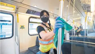  ?? JONATHAN HAYWARD THE CANADIAN PRESS ?? Cleaners disinfect train cars of the Sky Train in Vancouver on Thursday.