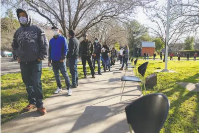  ?? Brittany Hosea-Small / Special to The Chronicle ?? More than 100 people wait for the vaccine at Napa Valley College. The flow of shots is expected to improve.