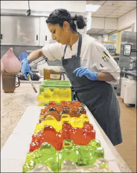  ?? Bizuayehu Tesfaye Las Vegas Review-Journal @bizutesfay­e ?? Andrea Madrid, assistant executive chef at Aria, uses a blow torch on a giant sugar bear for the gingerbrea­d house.