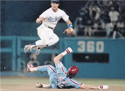  ?? THE ASSOCIATED PRESS ?? Steve Sax, shown leaping over Mike Schmidt in 1984, was one of many players voicing a character on an episode of The Simpsons.