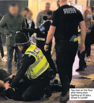  ??  ?? Two men on the floor after being seen fighting on St Mary Street in Cardiff