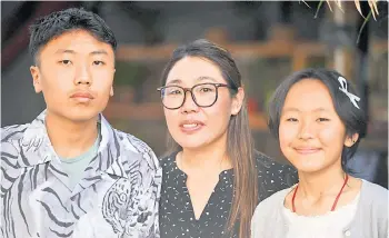  ?? — AFP photos ?? Nima Doma (centre), wife of avalanche victim and mountainee­r Tsering Onchu Sherpa who died in the 2014 avalanche, posing for a picture with their son Pemba Chetten Sherpa (left) and daughter Nima Yangji Sherpa during an interview with AFP in Kathmandu.