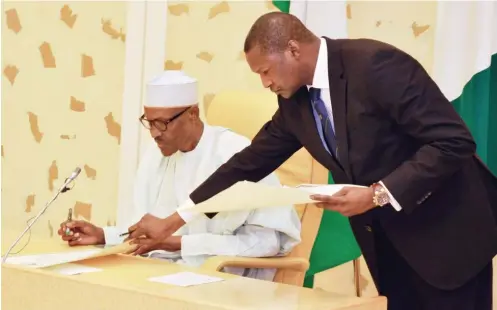  ?? Photo: Felix Onigbinde ?? President: President Muhammadu Buhari signs the instrument­s of ratificati­on for internatio­nal agreements between Nigeria and other entities at the Presidenti­al Villa in Abuja yesterday. With him is the Minister of Justice and Attorney General of the Federation, Abubakar Malami