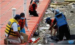  ??  ?? Dangerous debris: Members of an environmen­tal group collecting medical waste at Cisadane river in Tangerang. — Reuters