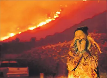  ?? Wally Skalij Los Angeles Times ?? EVA SMATHERS reacts to the flames from the Thomas fire bearing down on the coastal enclave of La Conchita in Ventura County.