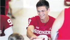  ??  ?? Quarterbac­k Connor McGinnis gives an autograph during Sunday’s Meet the Sooners Day in Norman.