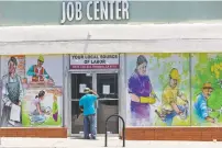  ?? DAMIAN DOVARGANES/ASSOCIATED PRESS FILE PHOTO ?? A person looks inside the doors of the Pasadena Community Job Center in May in Pasadena, Calif. While most Americans have weathered the pandemic financiall­y, about 38 million say they are worse off now than before the outbreak began.